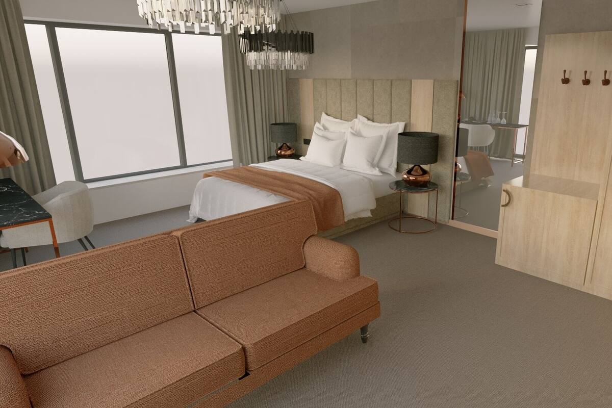 Een moderne hotelkamer met een groot bed, een bank, een bureau en een kledingkast.