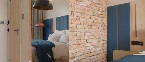 A modern bedroom with a brick accent wall, a bed with blue bedding, and a large mirror.