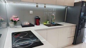 A modern kitchen with a built-in stove, a sink, and a refrigerator.