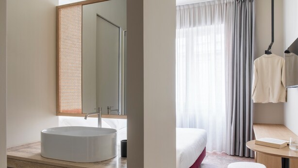 A modern bathroom with a round sink, a mirror, and a towel rack. - Atel Relais (Rome)
