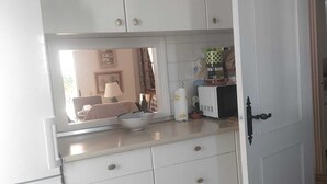 A kitchen with white cabinets, a countertop, and a door. - Beautiful house 30 meters from the sea (Almonte)