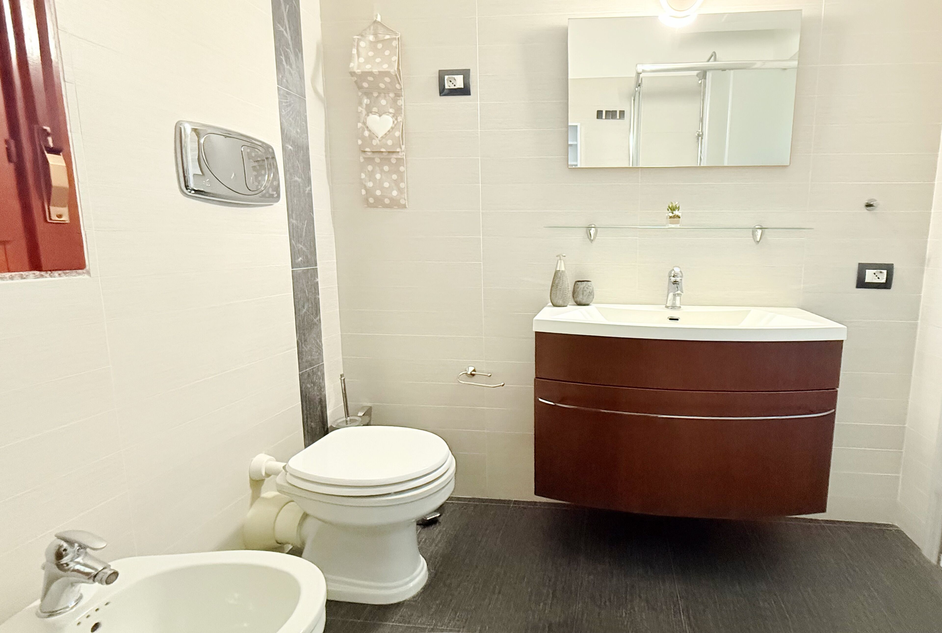 A bathroom with a toilet, sink, and vanity.
