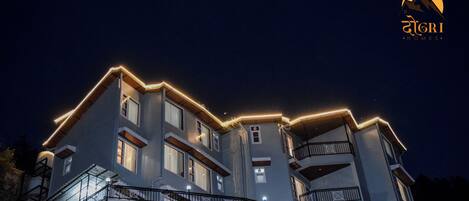 A multi-story building with a modern architectural design, featuring balconies and a prominent roofline.