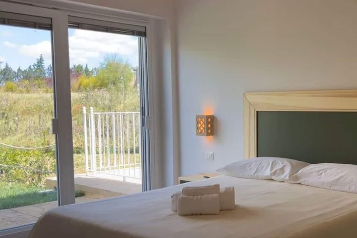 A bedroom with a bed, bedside tables, and a phone.