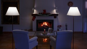 Una sala de estar con chimenea, dos sillones y dos lámparas de pie.