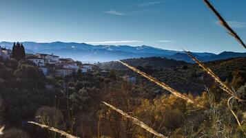 Paisaje montañoso con un pueblo de edificios blancos y cielo despejado.