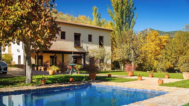 A house with a swimming pool, surrounded by potted plants and trees. - San Acacio Mill - Genil Rural House (Huetor De Santillan)
