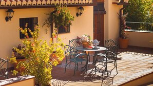 A traditional building with a tiled roof, a small porch with outdoor seating, and potted plants. - San Acacio Mill - Genil Rural House (Huetor De Santillan)