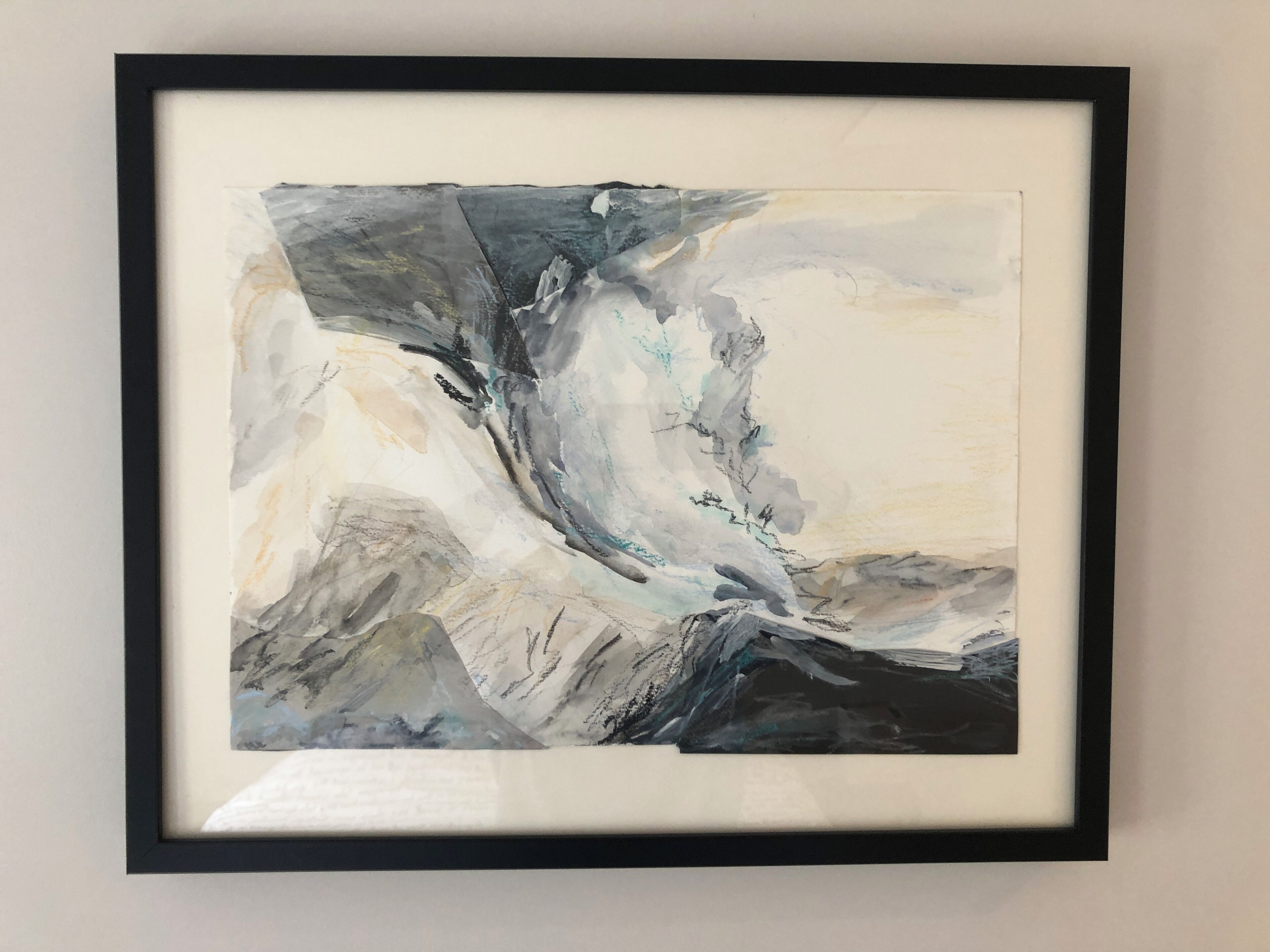 A framed abstract painting with a black frame.
