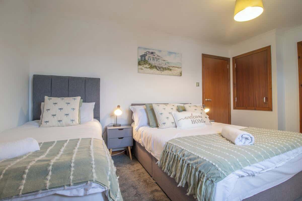 Una camera da letto con due letti, un comodino e un quadro appeso al muro.
