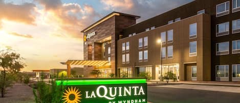 Un hotel de diseño moderno, con un cartel llamativo de 'La Quinta by Wyndham' y una entrada bien iluminada.