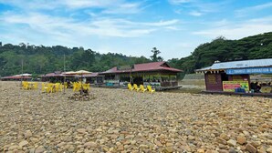 A riverside area with a restaurant and a tourist information booth. - Hotel O Asiacamp Resort National Park Kuala Tahan (Kuala Tahan)