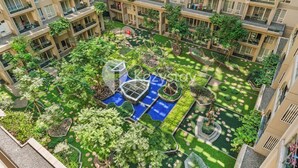 A multi-story residential building with a rooftop garden featuring pathways, greenery, and a small water feature. - Sedana by Kozystay - Paskal (Bandung)
