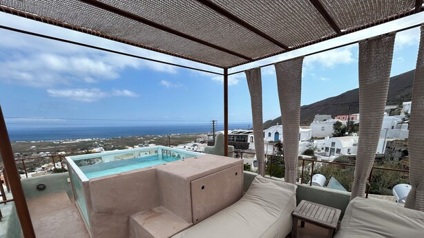 A balcony with a view of the sea and white buildings, a small pool, and a beige sofa. - Villa Pasithea, Finikia, Oia, Santorini (Oia)