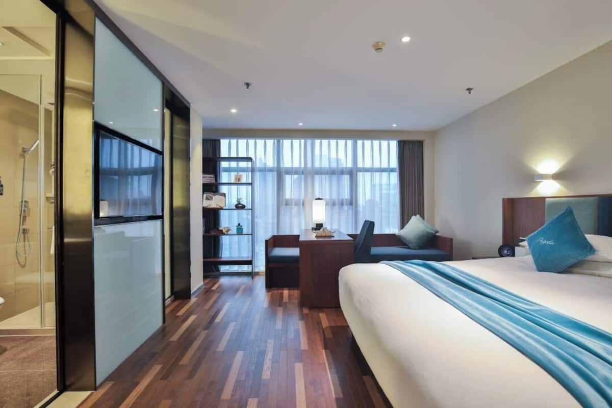 Ein modernes Hotelzimmer mit einem großen Bett, einem Schreibtisch und einer Sitzecke.