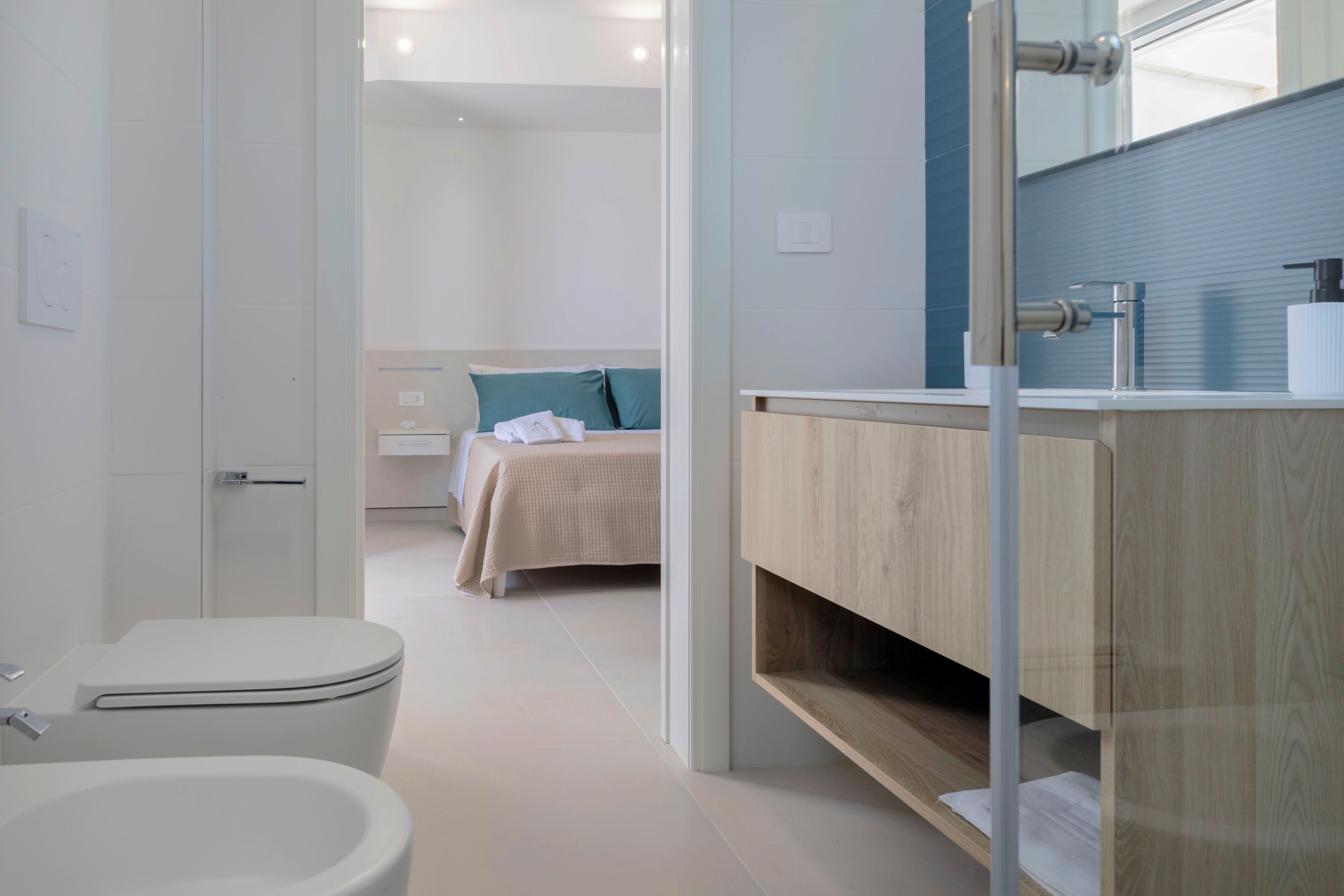 A modern bathroom with a toilet, sink, and mirror.