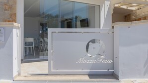 Lasinen sisäänkäyntiovi, jossa on logo ja nimi ”Mozza Fiato” valkoisessa paneelissa.