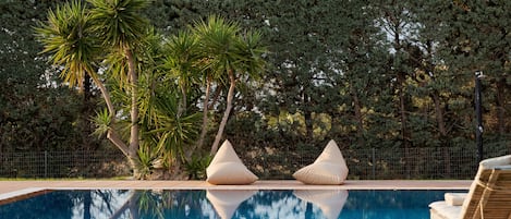 Piscine extérieure en saison, chaises longues