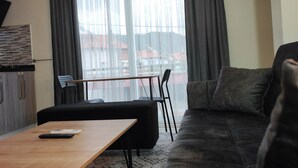 Un soggiorno moderno con un divano, un tavolino in legno e un'area pranzo con tavolo e sedie.