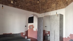 Ein Schlafzimmer mit einem Bett, einem Stuhl, einem Kleiderschrank und einem Spiegel.