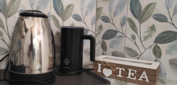 A kitchen counter with a stainless steel kettle, a black mug, and a wooden sign that says "I ♥ TEA". - Family-friendly vacation home within walking distance of the sea, station and port (Civitavecchia)