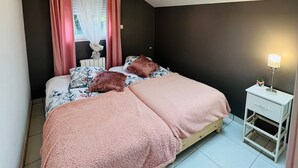A bedroom with a skylight, a bed with pink bedding, a bedside table with a lamp, and a window with curtains. - 20 MIN PARIS/ 10 MIN ORLY AIRPORT CASA PARADIS VERT (Villeneuve-le-Roi)