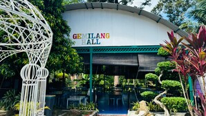 The exterior of Gemilang Hall with a white facade, green trim, and a sign above the entrance. - Capital O 91167 Gemilang Candi Resort (Merbok)