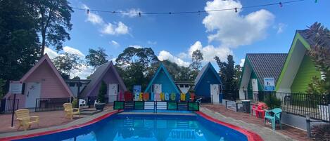 A swimming pool with colorful triangular buildings in the background.