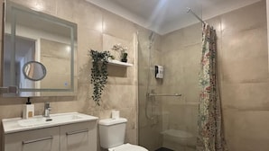 A modern bathroom with a toilet, sink, and shower.
