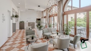 A modern lobby with checkered flooring, seating areas, and large windows offering views of the outside. - Hotiday Venezia Cape (Venice)