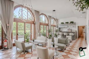 Un'ampia zona giorno con grandi finestre, una cucina con posti a sedere al bancone e un estintore a pavimento.