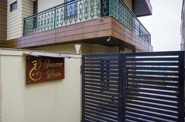 A building with a balcony featuring ornate metal railings and a sign that reads "Summer House." - Summer Villa (Mussoorie)