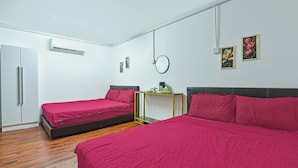 Une chambre avec deux lits, une petite table et un miroir au mur.