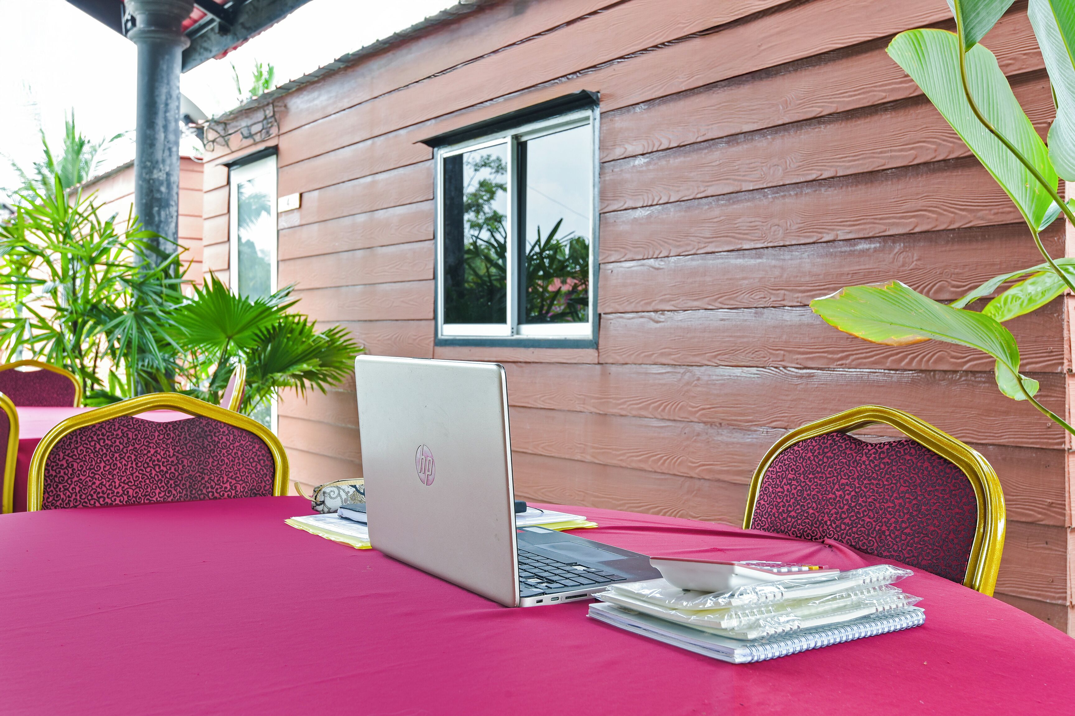 A wooden cabin with a table set for two, featuring a laptop and notebooks.