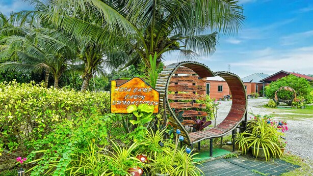 Un jardin tropical avec une pancarte indiquant « Asia Camp Cabin Sungasari ».