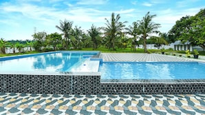 Une piscine avec des marches recouvertes de carreaux et un chemin décoré.