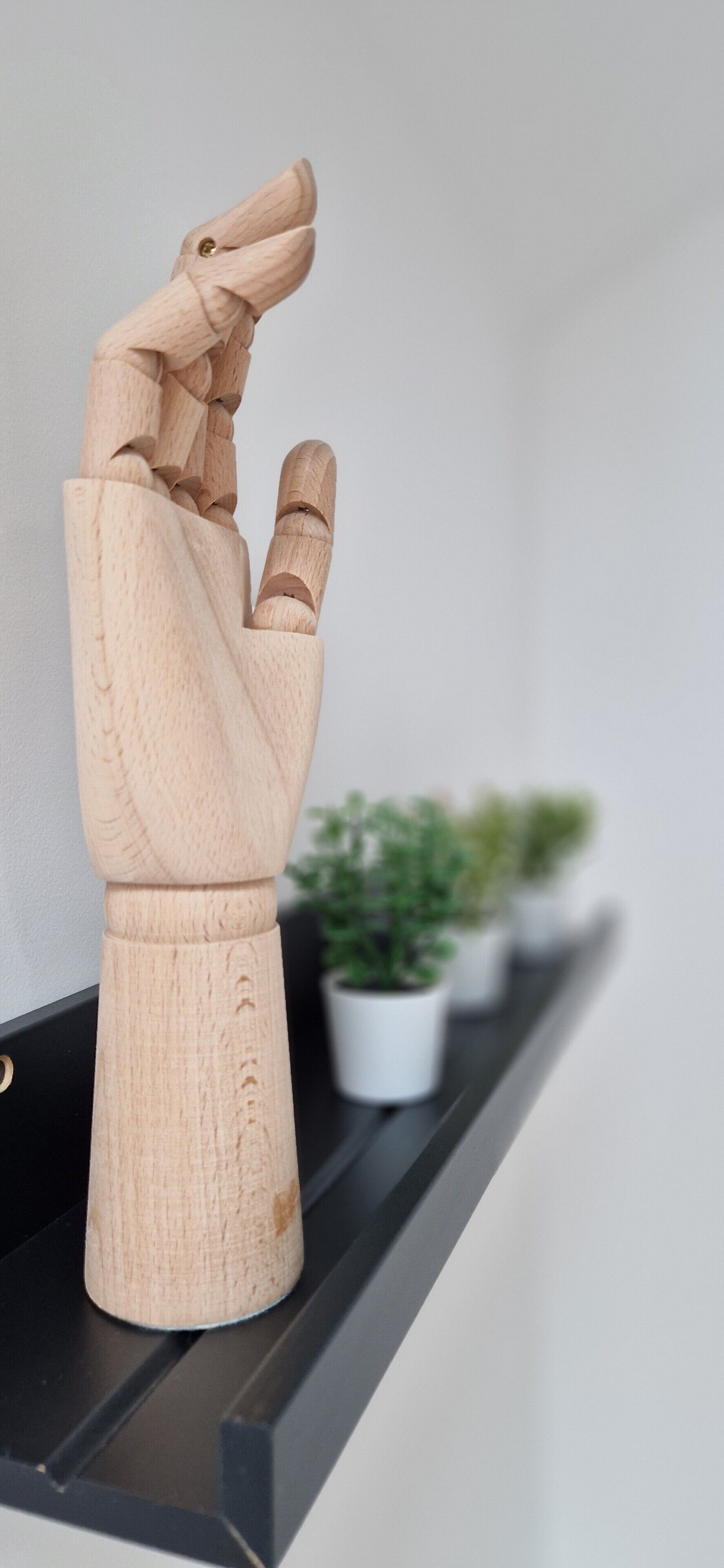 Una scultura in legno raffigura una persona su uno scaffale.