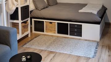 Un dormitorio moderno con cama, mesitas de noche, un sofá y una mesa redonda.