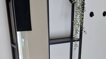 Un baño moderno con un espejo de marco negro, un lavabo redondo y un mueble de tocador de madera.