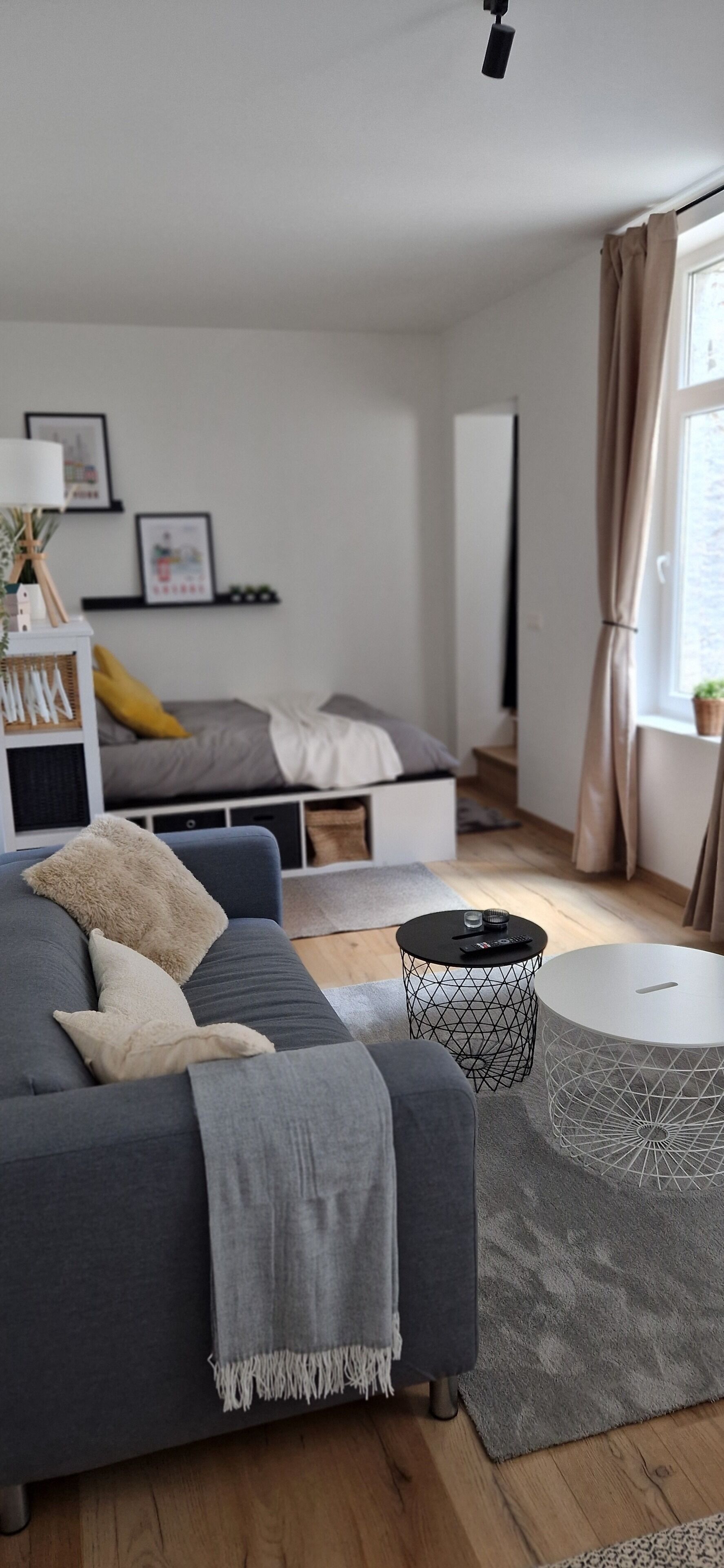 Ett modernt vardagsrum med en grå soffa, ett runt soffbord och en grå matta.
