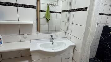 Een douche, handdoeken, toiletpapier