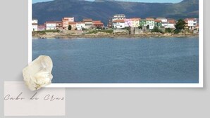 A coastal town with buildings along the water, a mountain in the background, and a large white crystal in the foreground. - Apartment with 2 double bedrooms (4 persons), 1 bathroom at 400 meters from the beach (Boiro)
