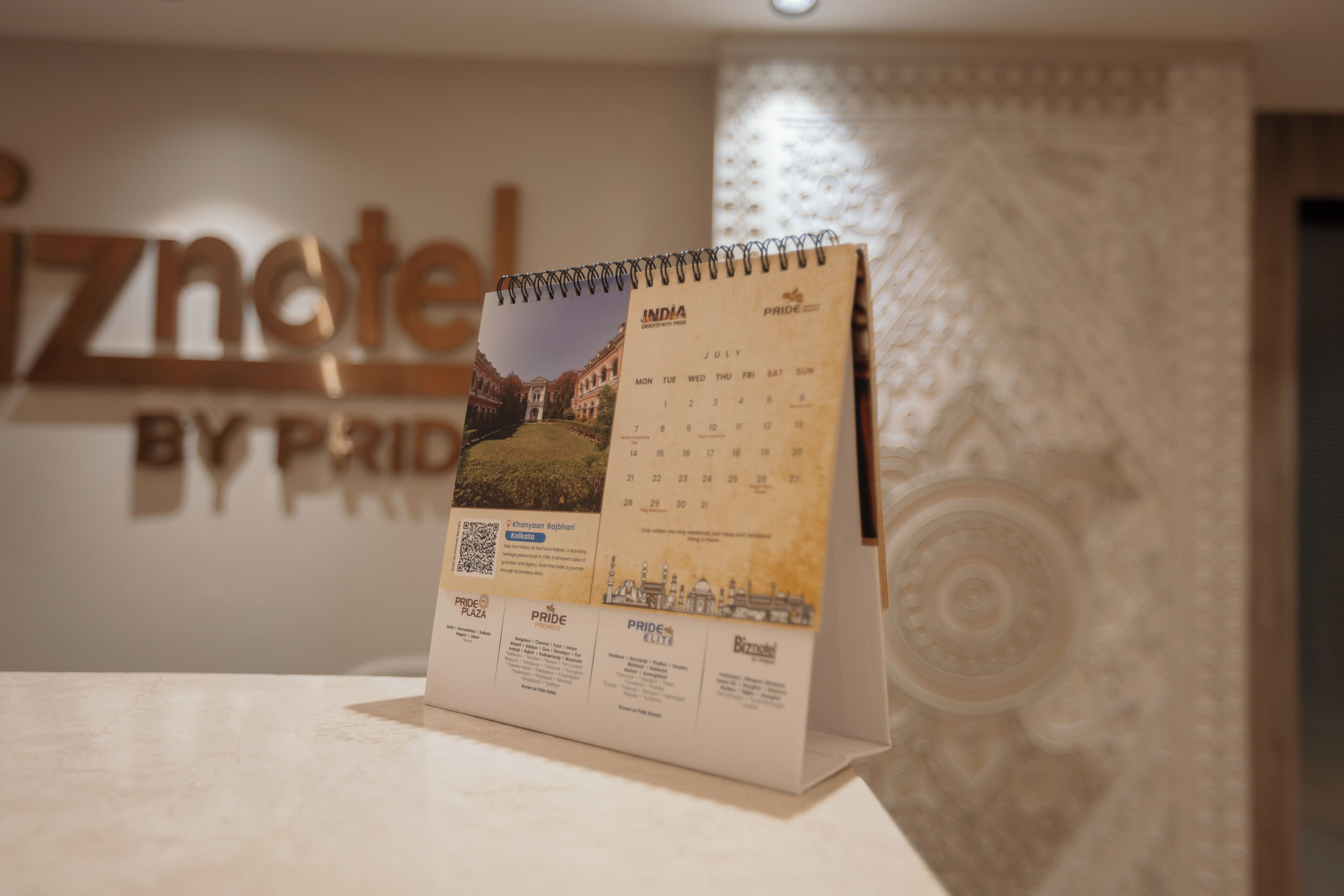 A calendar with a view of a building, possibly a hotel, and the text "PRIDE" and "INDIA" visible.