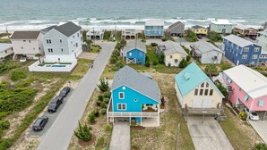 Une zone résidentielle côtière avec des maisons, une route et l’océan en arrière-plan.