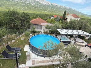 Piscina com hidromassagem, área de estar ao ar livre e vista para uma paisagem montanhosa.