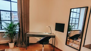Een moderne kantoorruimte met een bureau, stoel en grote spiegel.