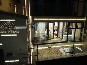 A hotel named 'Vita Resort' with a modern design, featuring a bar area with a glass partition, a seating area with chairs and a table, and a visible bathroom.
