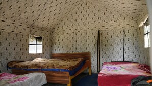 A room with a wooden bed, a smaller bed, and a window. - The Little Pahadi (Ukhimath)