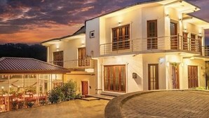 A two-story building with a balcony and a covered outdoor seating area. - Villa Grand Mellow (Nuwara Eliya)