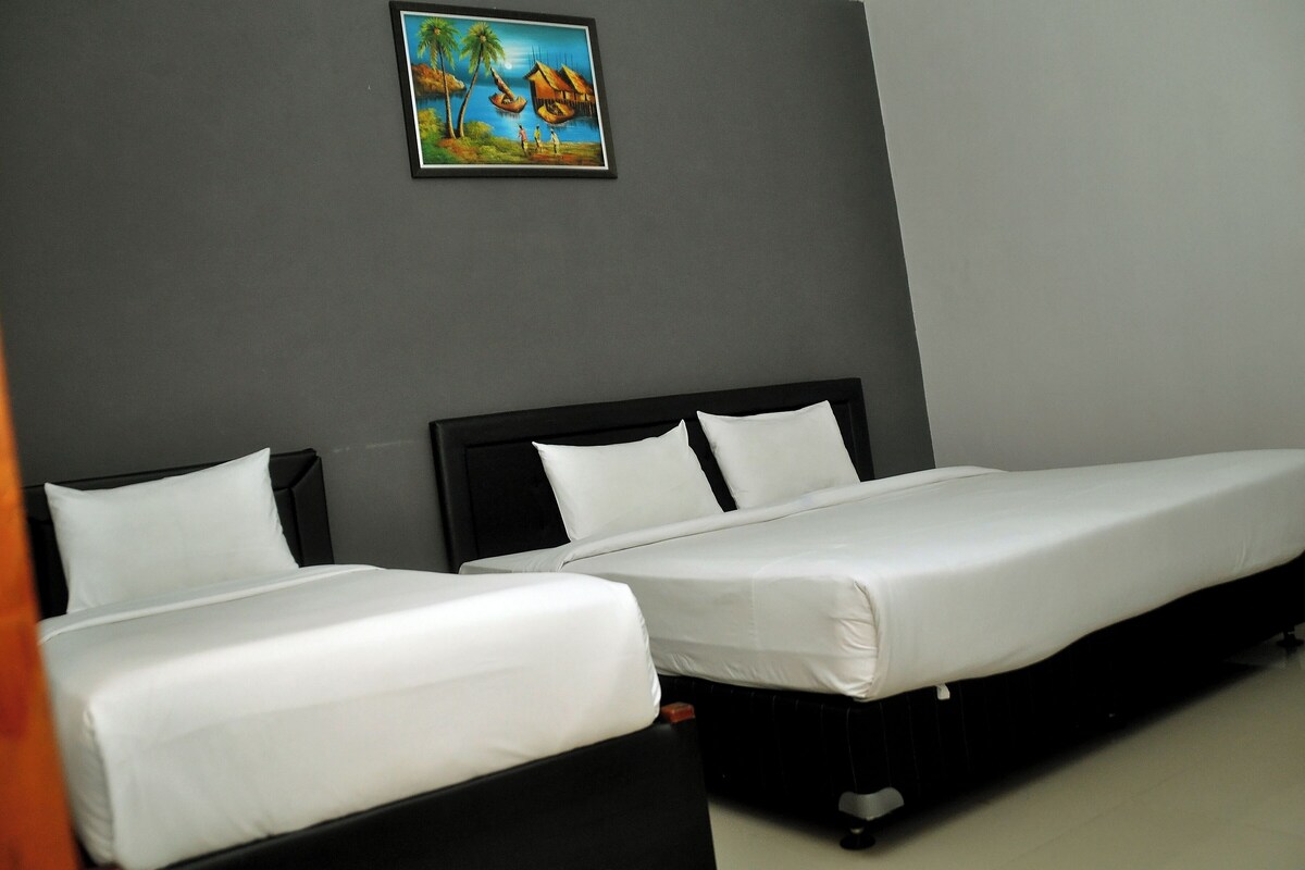 Quarto de hotel com duas camas de solteiro, cabeceira escura e um quadro na parede.